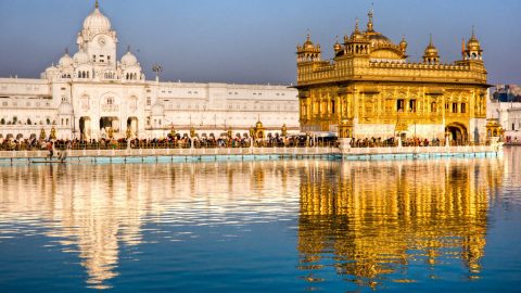A view of golden temple with its beautiful image in water parallel to it.