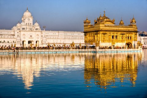 A view of golden temple with its beautiful image in water parallel to it.